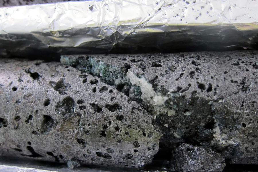 A core sample from the Carbfix project, showing that white carbonate has been formed in the basalt from injected CO2.