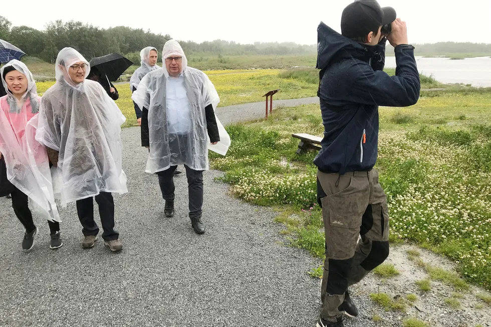 Statssekretær Atle Hamar i Klima- og miljødepartementet (til høyre) og Kinas viseminister for miljø og økologi Zhai Qing i regnponcho besøker våtmarksområdet Rusasetvatnet på Ørland. Foran går ornitolog Jørgen Søraker.