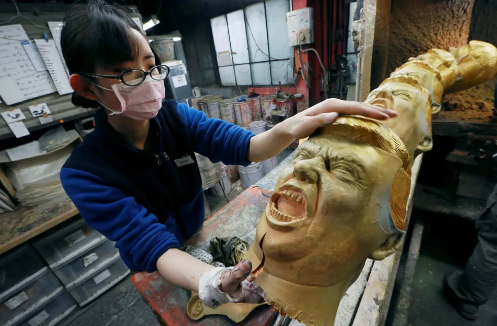 USAs president Donald Trump har lovet lavere skatter for næringslivet. Det legger press på Kina og Japan for å gjøre det samme. Her lager en arbeider hos Ogawa Studio i Tokyo en Trump-maske. Foto: Eugene Hoshiko/AP/NTB Scanpix