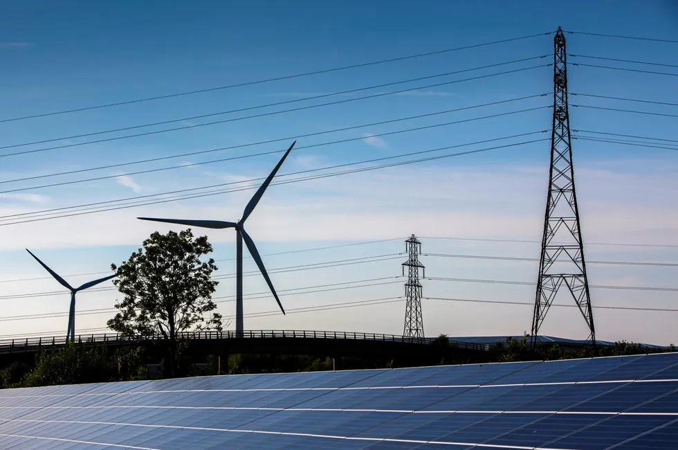 Wind turbines, solar panels and electricity transmission lines in southwest England.
