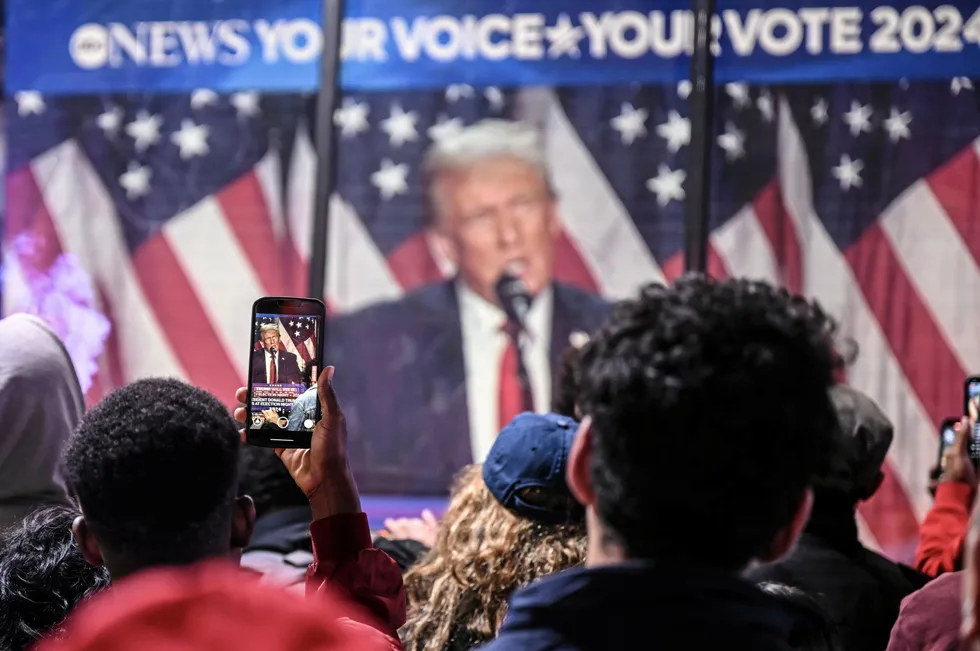 New York residents watch Donald Trump's speech on a screen as vote counting was under way on Tuesday evening.