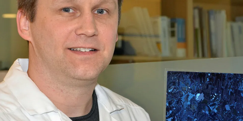 WAFER: Rune Søndenå viser her frem en wafer: en tynn skive som er skåret ut av en såkalt ingot. Waferen er laget av multikrystallinsk silisium.