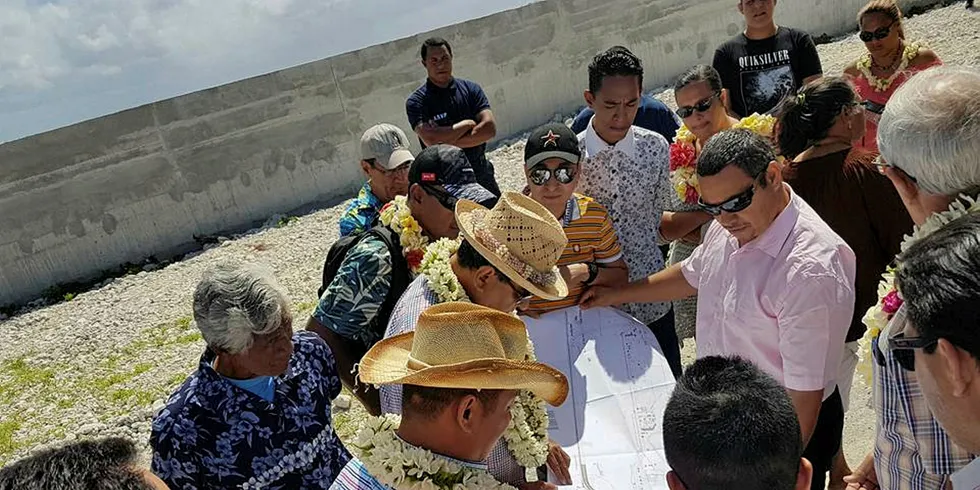 Execs look over plans for the huge Chinese-owned fish farm set for construction on Hao atoll.