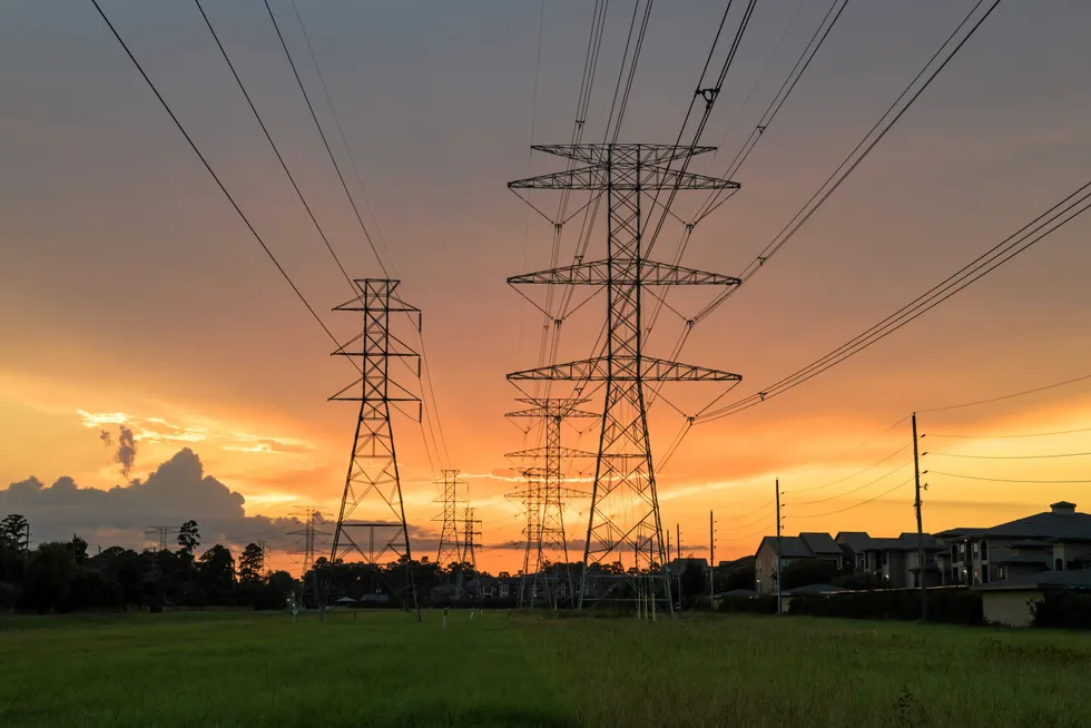 Group silhouette of transmission towers at sunset in Humble, Texas.