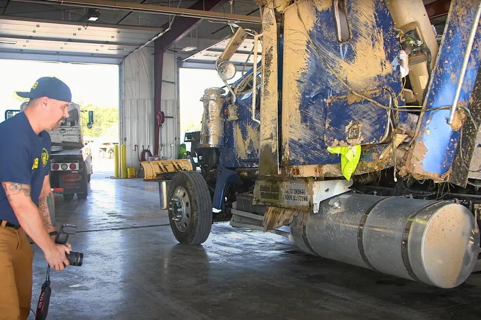 The crashed ammonia tanker truck being photographed, in a screenshot from a video released by the National Transportation Safety Board.
