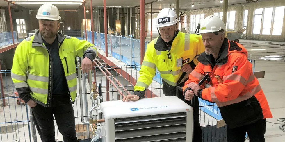 Mobil byggtørkløsning: Fv. Bjørn Peder Andersen (Brødrene Dahl). Pål Høsøien (Hent) og Morten Sund (Mo Fjernvarme) med en mobil varmevifte som drives med fjernvarme. Her i forbindelse med bygging av det nye fellesbygget på Polarsirkelen Vgs.