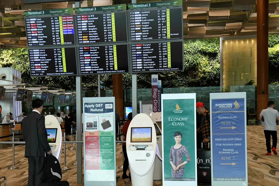 En Singapore Airlines-passasjer sjekker inn ved de automatiske innsjekkingsboksene på utenlandsterminalen ved Changi-flyplassen i Singapore torsdag 11. oktober.