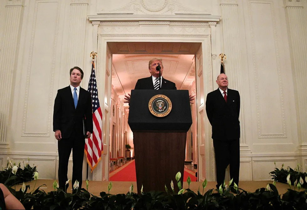 Brett Kavanaugh (til venstre) og pensjonert høyesterettsdommer Anthony Kennedy (til høyre) hører på Donald Trumps tale under seremonien i Det hvite hus mandag.
