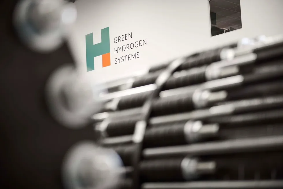 The Green Hydrogen Systems logo behind one of its pressurised alkaline electrolysers.