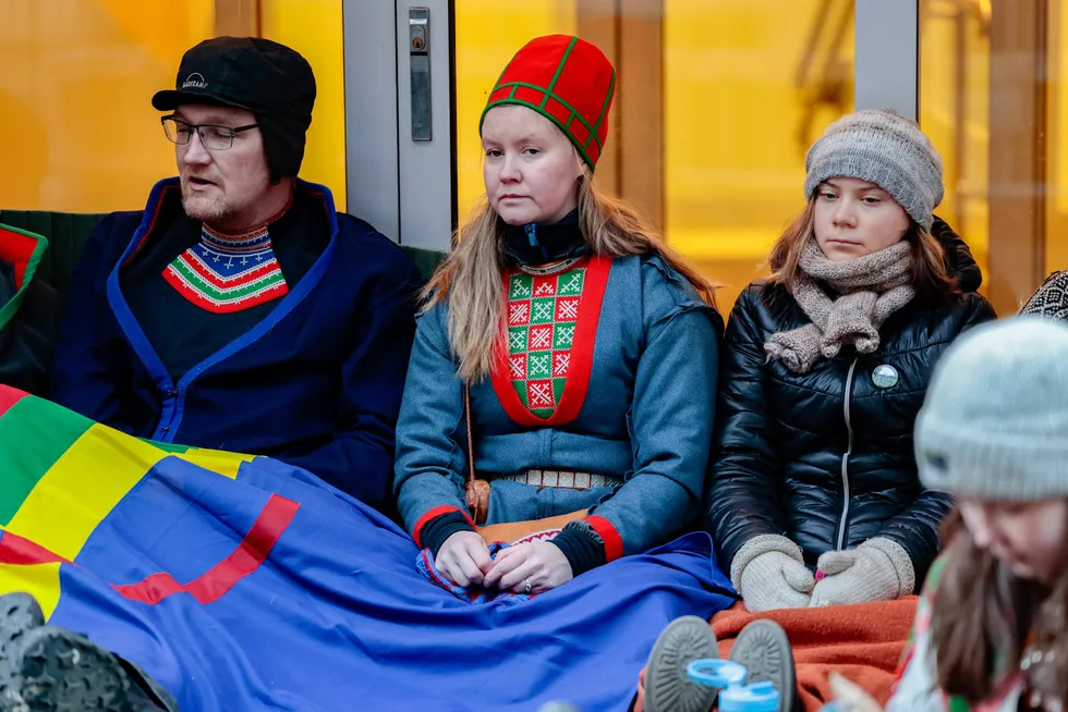 Greta Thunberg (til høyre) er blant aksjonistene som torsdag morgen satt foran inngangen til Nærings- og fiskeridepartementet.