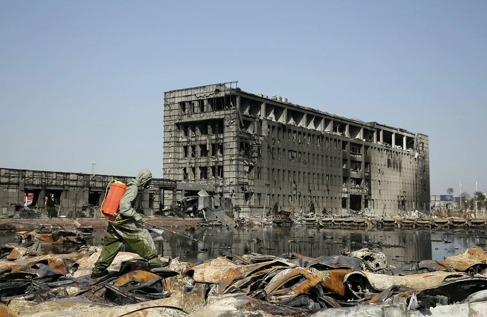 FILE PHOTO: A People's Liberation Army (PLA) soldier of the anti-chemical warfare corps in protection suit sprays liquid on the debris at the site of last week's blasts in Binhai new district of Tianjin, China, August 21, 2015.REUTERS/Stringer/File Photo CHINA OUT. NO COMMERCIAL OR EDITORIAL SALES IN CHINA. Foto: CHINA STRINGER NETWORK