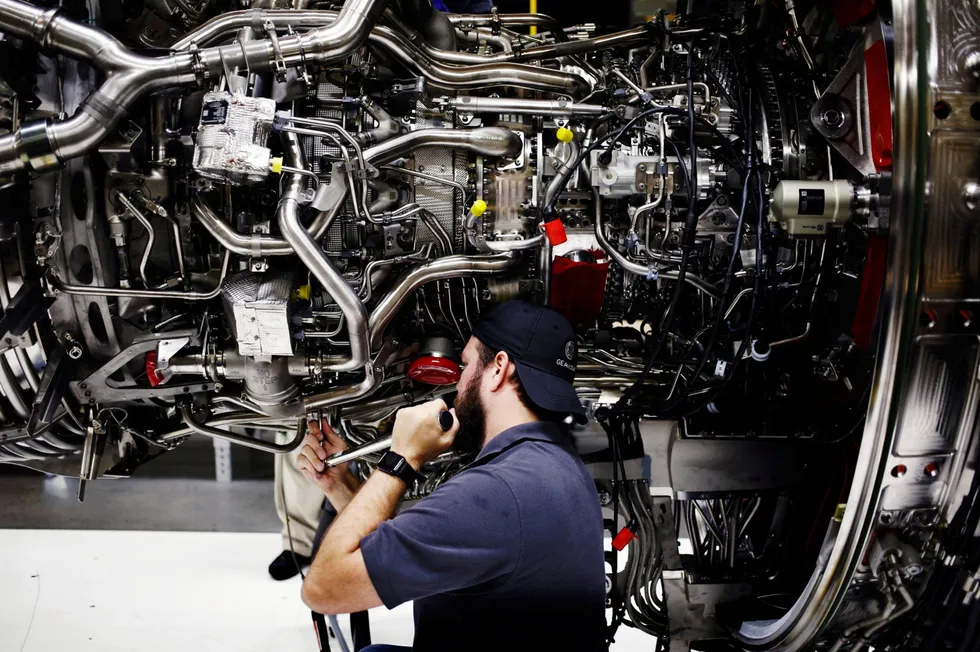 General Electric deles opp i tre selskaper. En ansatt skrur sammen en flymotor på deres flyfabrikk i Lafayette.