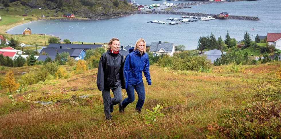 GODE FOR MILLIONER: Søstrene Aino og Maria Olaisen er på tur oppover siden av Lovundfjellet. Bak ser vi Nova Seas lakseslakteri. Søstrene driver firmaet videre fra Lovund, og er sentrale for sysselsettingen og bosettingen der ute.