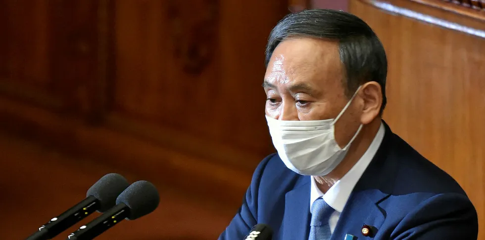 Japan's Prime Minister Yoshihide Suga wearing a face mask, gives his policy speech during an extraordinary session at the lower house of parliament in Tokyo on October 26, 2020.