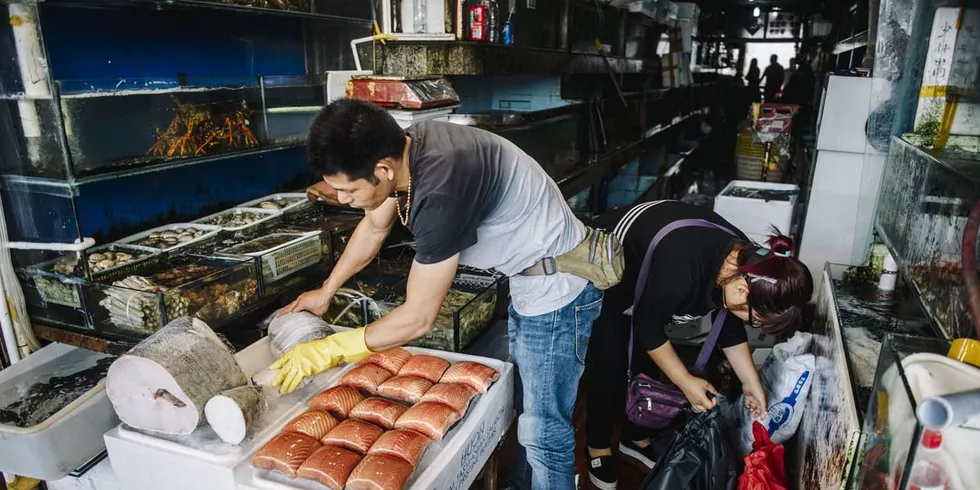 Fiskehandlere på fiskemarkedet i Shanghai med norsk laks. Nå selges norsk laks til Østen for opp mot 80 kroner kiloet. Foto: Fartein Rudjord