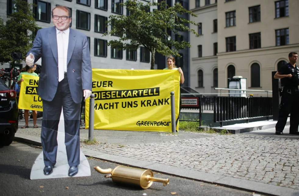 Demonstranter utenfor Tysklands føderale departement for transport og digital infrastruktur med en plakat av transportminister Alexander Dobrindt - som i dag møter Tysklands omstridte bilindustri. Foto: REUTERS/Hannibal Hanschke