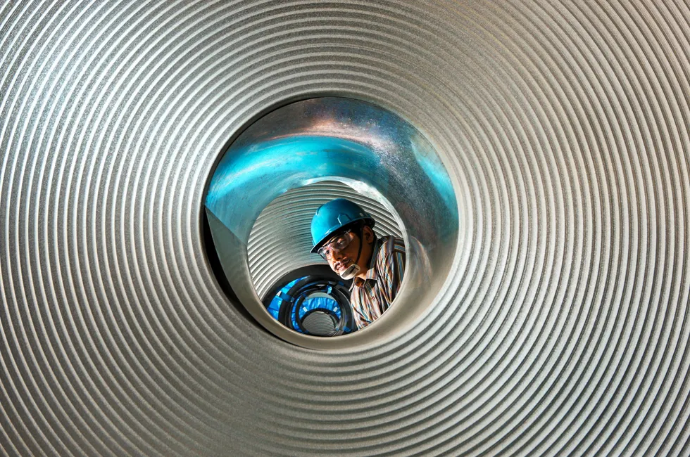 A supervisor examines a batch of rolled steel at a plant in Jharkhand, India.