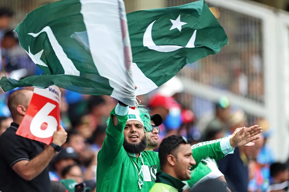 A Pakistan fan waves his country's national flag during the ICC Champions Trophy cricket match between Pakistan and India in February 2025.