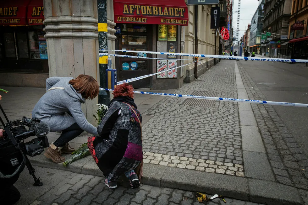 Søstrene Ilja og Loes Hermans fra Nederland legger ned tulipaner fra hjemlandet mens de bearbeider bildene fra kvelden i forveien. Foto: Linus Sundahl-Djerf