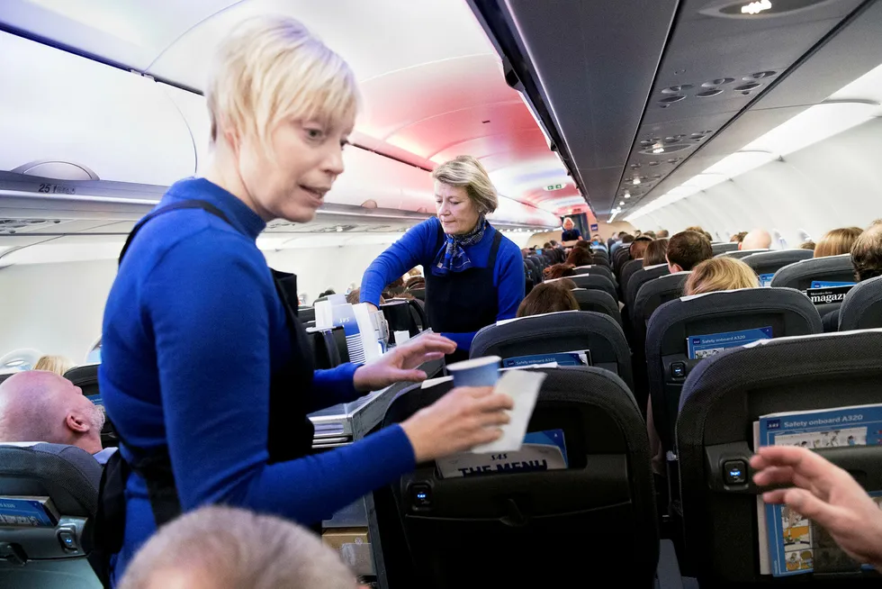 SAS' morgenfly fra Oslo til Stockholm var fullt tirsdag, men lønnsomheten har falt i høst. Flyvertinnene Leena Blomqvist (foran) og Marie Holmer forsyner passasjerene på selskapets nye flymodell, Airbus A320neo. Foto: Elin Høyland