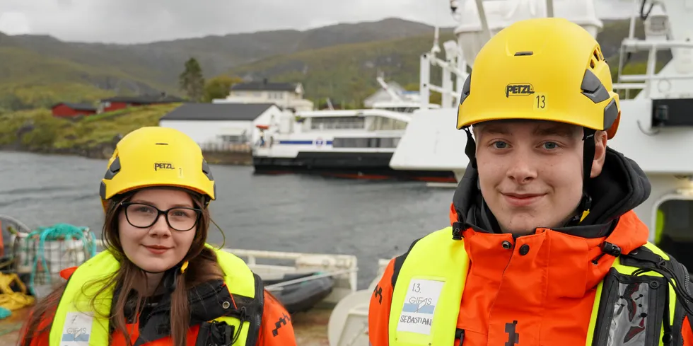 Eir Linnea Didriksen og Sebastian Lieng foran havna tilknyttet skolen på Inndyr i Nordland.