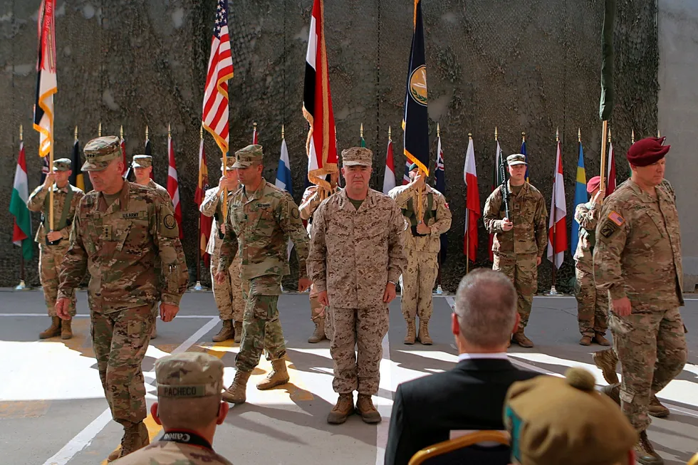 Iraks folkevalgte krever at landets regjering må kaste ut den USA-ledede militærkoalisjonen som er i landet. Dette bildet fra september viser amerikansk befal under en seremoni på en militærbase i Bagdad. General Kenneth F. McKenzie Jr (i midten) var øverste leder for aksjonen som tok livet av IS-leder Abu Bakr al-Baghdadi i nabolandet Syria.