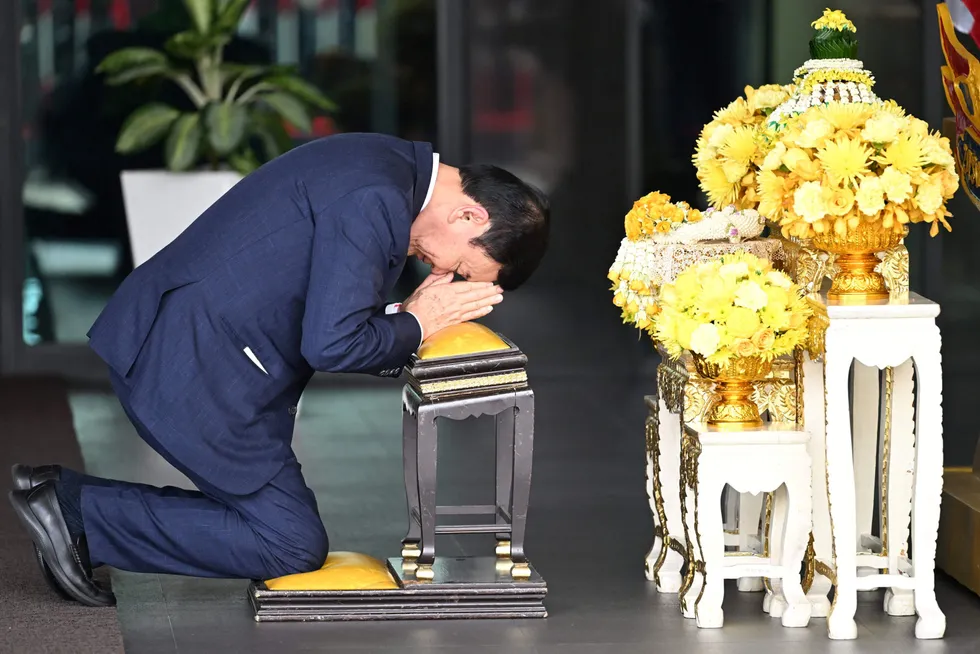 Thailands tidligere statsminister Thaksin Shinawatra knelte foran portrettet av Thailands konge tirsdag morgen – før han ble arrestert.