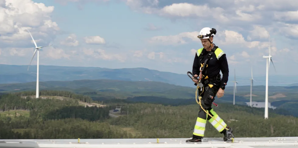 . En ansatt fra Akershus Energi Vind på toppen av en turbin på Engerfjellet, Odal Vindkraftverk.