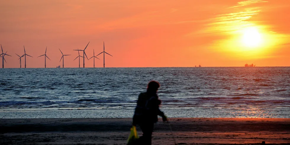 The sun sets over the Burbo Bank wind farm in the Irish Sea