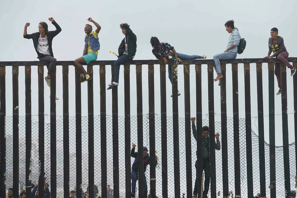Pentagon mener de har frigitt midler som er nødvendige i henhold til at det er nasjonale krisetilstander ved grensa mot Mexico. Arkivfoto: Demonstranter klatrer muren mellom USA og Mexico i San Ysidro, California