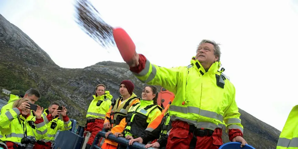 OPPDRETTSVEKST: Fiskeriminister Harald Tom Nesvik (Frp) kaster fôr i laksemerda på lokaliteten Krabbestig til Marine Harvest i Fåfjorden ved Måløy.Foto: Einar Lindbæk