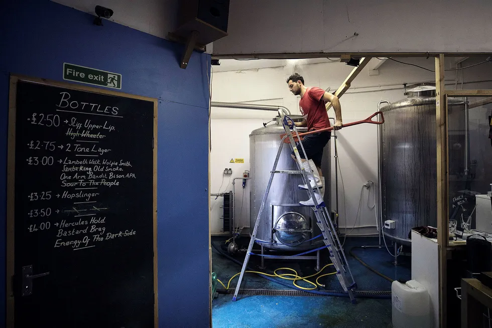 Trenden med håndverksøl er i ferd med å nå toppen internasjonalt. En ølbrygger sjekker temperaturen på ølet som lages på By The Horns Brewing i London. Foto: Simon Dawson/Bloomberg
