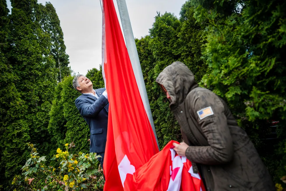 Norwegian-sjef Jacob Schram (bak) heiste onsdag selskapets flagg på hovedkontoret til ære for pressen og for å markere at selskapet antagelig har overlevd korona.