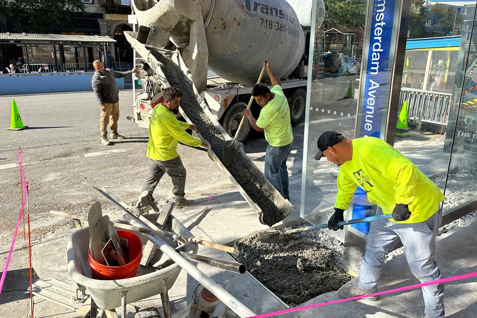 Amerikanske arbeidere skyfler sement i bakken ved et busstopp i Manhattan i New York.