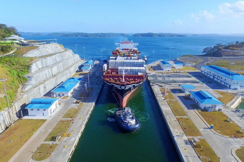 A tug guides a cargo vessel through the Panama Canal.