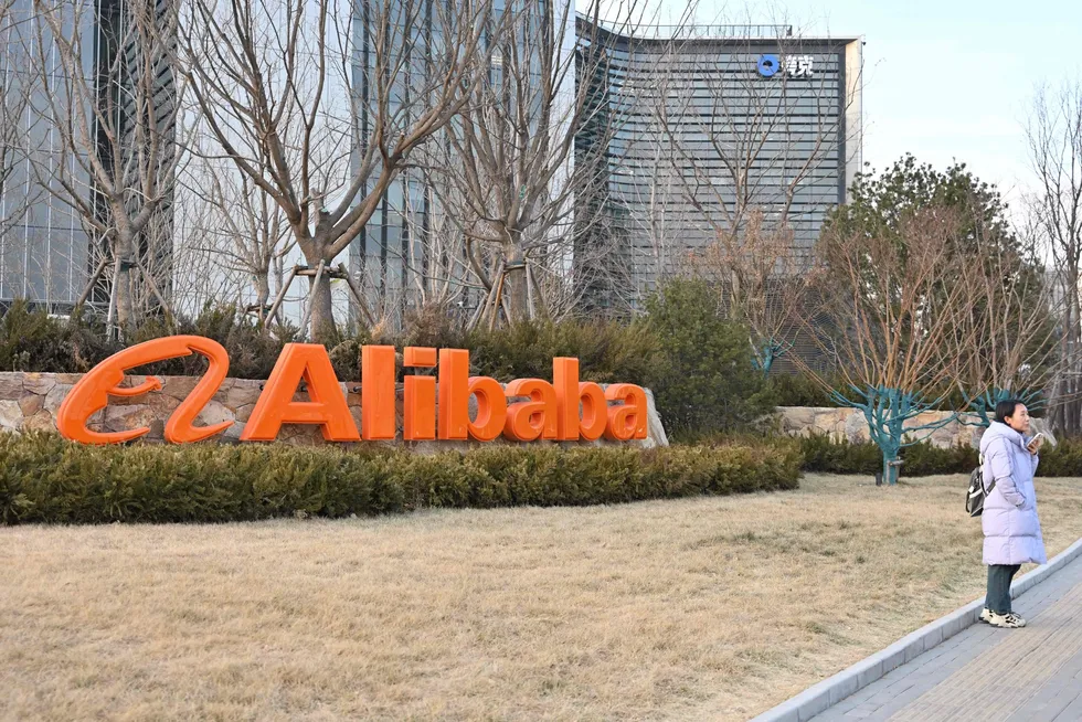 A woman stands in front of Alibaba’s offices in Beijing on February 14, 2025. a. Alibaba shares soared by more than six percent on February 14, following reports that Chinese president Xi Jinping was poised to meet with the tech juggernaut’s co-founder Jack Ma. (Photo by ADEK BERRY / AFP)