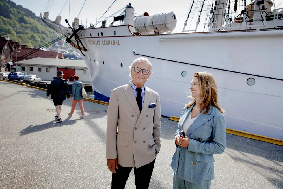 Herman Friele (til venstre) og kona Renate Hjortland feirer 17. mai hjemme i Bergen og skal se morgenprosesjonen fra sidelinjen. I fjor solgte de unna eiendom og andeler i en kaffeplantasje, og har over én milliard kroner å kjøpe for. I bakgrunnen fullriggeren «Statsraad Lehmkuhl». Foto: Paul S. Amundsen