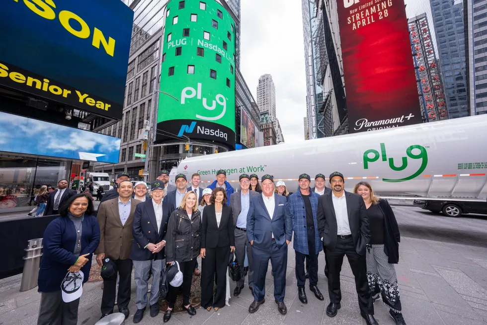 Plug Power staff posing at the Nasdaq building in New York in 2022 after introducing its new corporate logo.
