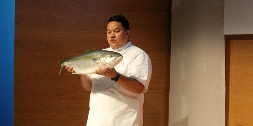 Sushikokk Jonathan Romano viser her frem en yellowtail kingfish (kongemakrell).