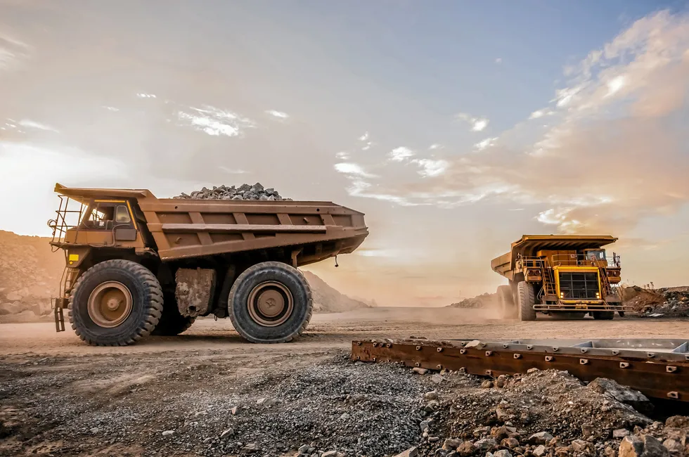 Gigantic off-road dump trucks carrying platinum-rich rock to a crusher at a mine in South Africa.