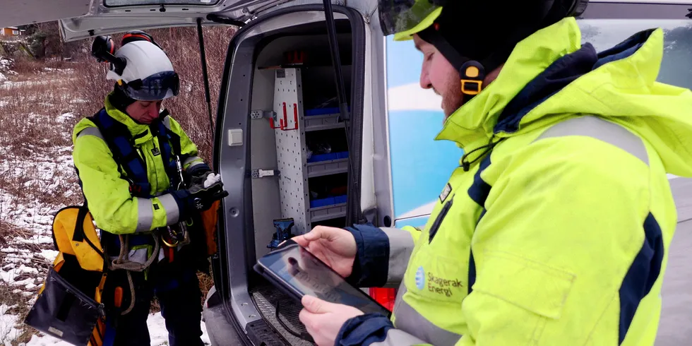 Mens Tor Olav Fjeldheim får på seg klatreutstyret, rapporterer Thomas Storås via Trimble UTG-systemet arbeid pågår.
