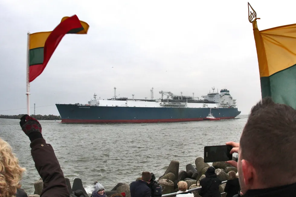 Witnesses wave Lithuanian national flags as they welcome the first liquefied natural gas floating regasification and storage vessel Independence in the port of Klaipeda in October 2014.