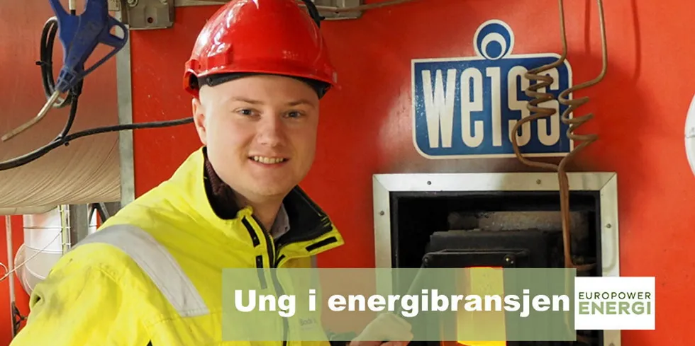 Her er Fredrik Pettersen ved innsynsluka til biokjelen til Bodø Energi Varme.