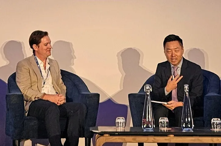 Andrew Beard, left, being interviewed on stage by WoodMac's Xizhou Zhou.