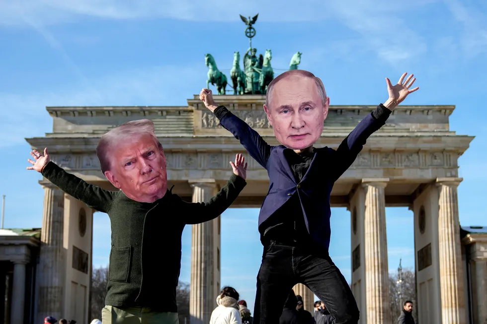 Demonstranter foran Brandenburger Tor i Berlin som bærer masker av USAs president Donald Trump og Russlands president Vladimir Putin.