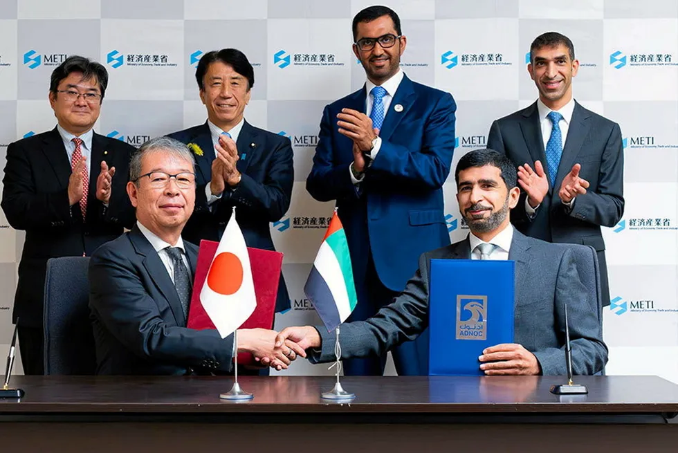 Adnoc and JBIC officials signing green financing deal.