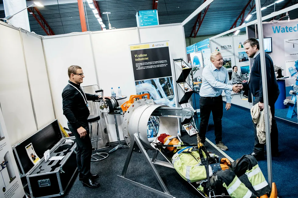 Gustav Paringer i Aptum (til venstre) selger vinsjer under oljemessen ONS i Stavanger. Ved siden av i blå skjorte står markedsfører Leo Heggström som snakker med Andreas Sjoström fra det store svenske stålkonsernet SSAB. De fleste som gikk forbi standen, måtte kaste et blikk på dukken som var hektet fast til vinsjen.