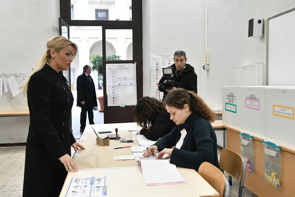 Francesca Pascale, som støtter ytre høyre partiet Forza Italias Silvio Berlusconi, gjør seg klar til å levere sin stemme da valglokalene åpnet i Roma søndag morgen. Foto: Tiziana Fabi, AFP/NTB Scanpix