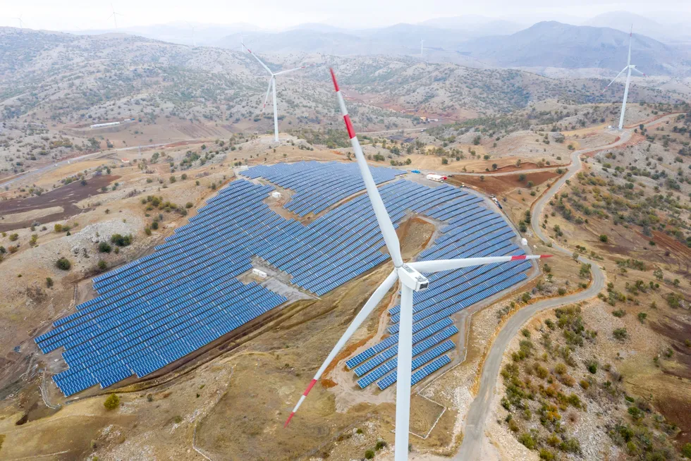 An aerial view of wind turbines and solar panels.