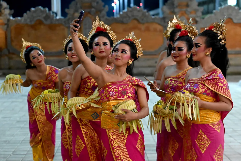 Welcome to Bali: traditional dancers take a selfie as they await the arrival of G20 leaders at Ngurah Rai international airport.